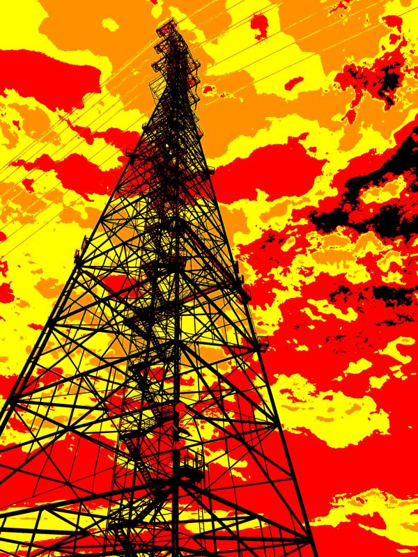 Silhouetted transmission tower against a vivid red and yellow sky.