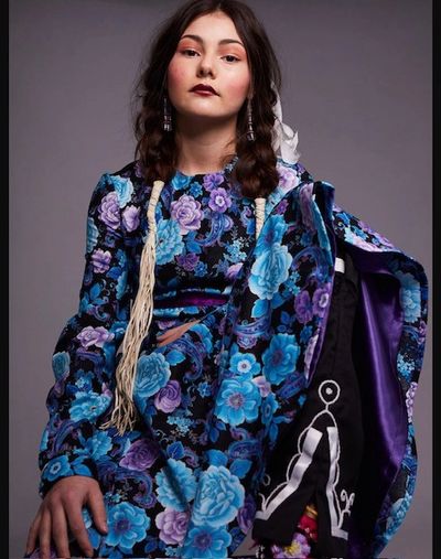 Woman in a blue floral dress posing.