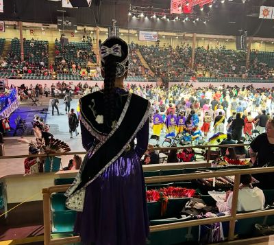 Person in traditional clothing at a large indoor event.