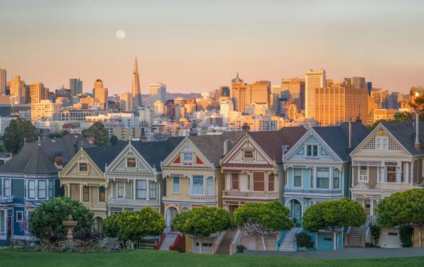 San Francisco's iconic Painted Ladies with city skyline at sunset.