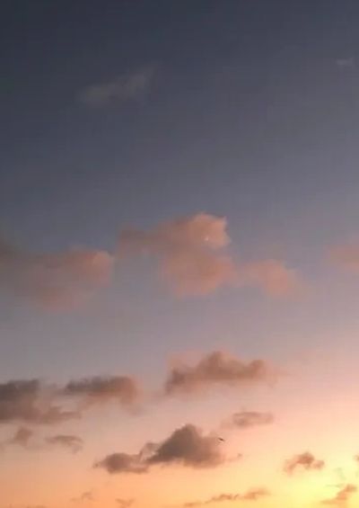 Sunset with scattered clouds and a clear horizon.