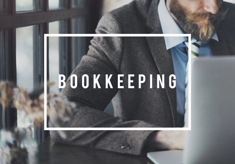Businessman working on bookkeeping at a laptop in an office.