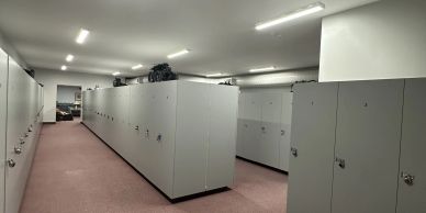 Rows of grey lockers in a well-lit room.