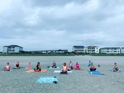 Group of people doing yoga on the beach