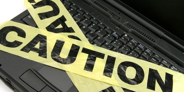 Computer with caution tape. Protect your computer against ransomware and hardware failure.