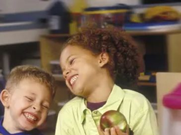 Two children laughing joyfully together.