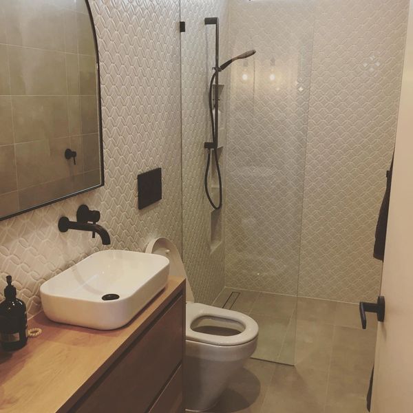 Modern bathroom with black fixtures and textured walls.
