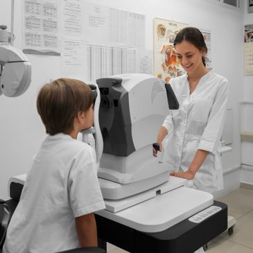 Eye exam with a young boy and an eye care professional using an advanced eye testing machine.