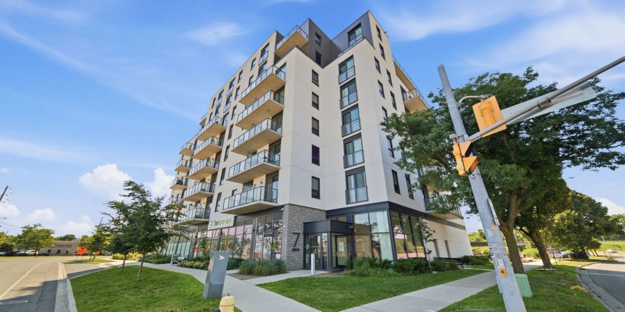Modern apartment building with balconies and greenery.