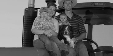 Family sitting on tractor with dog and two children.