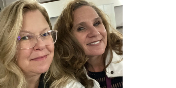 Two women smiling, wearing name tags at a health services event.