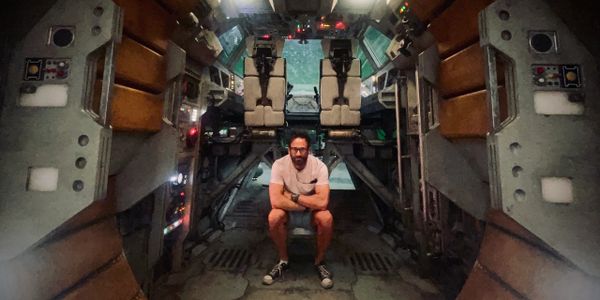A man sits inside a futuristic, spaceship-like cockpit.