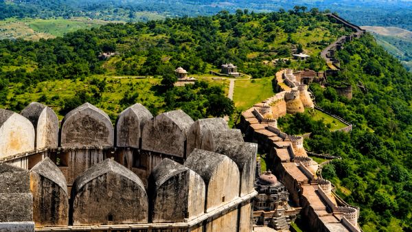 A historic fort wall winding through lush green hills.