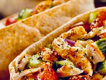 Close-up of grilled chicken wraps with fresh vegetables.