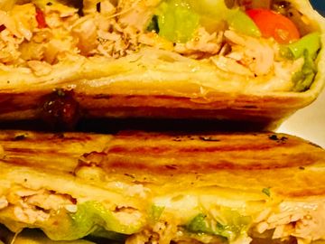 Close-up of grilled chicken and vegetable sandwich halves.