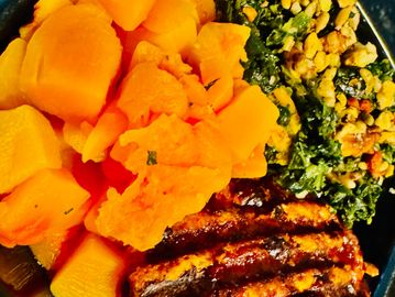 Grilled meat with cooked pumpkin and sautéed greens topped with crunchy nuts.