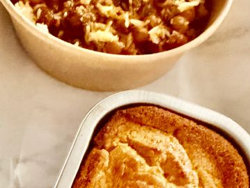 A meal with cornbread and chili in containers.