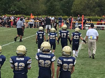 Spring-Ford Youth Football & Cheer coach and players meeting their opponent and refs before a game.