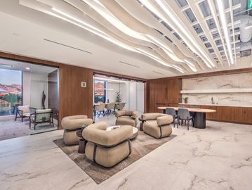 Modern office lounge with padded chairs.