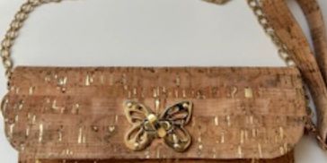 Brown cork handbag with gold butterfly clasp and chain strap.