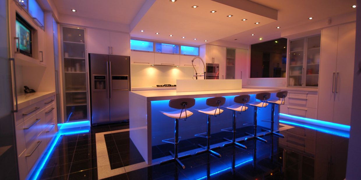 Modern kitchen with blue LED lighting under the island and cabinets.