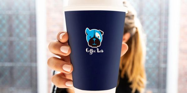 Person holding a coffee cup with a blue dog logo labeled 'Coffee Lab'.