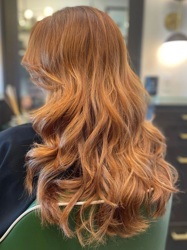 copper toned all over color curled wavy hair