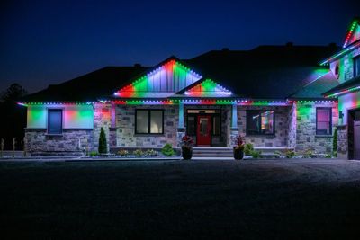 A house decorated with multicolored LED lights at night.