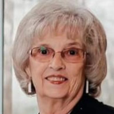 Portrait of an elderly woman with glasses and white hair.