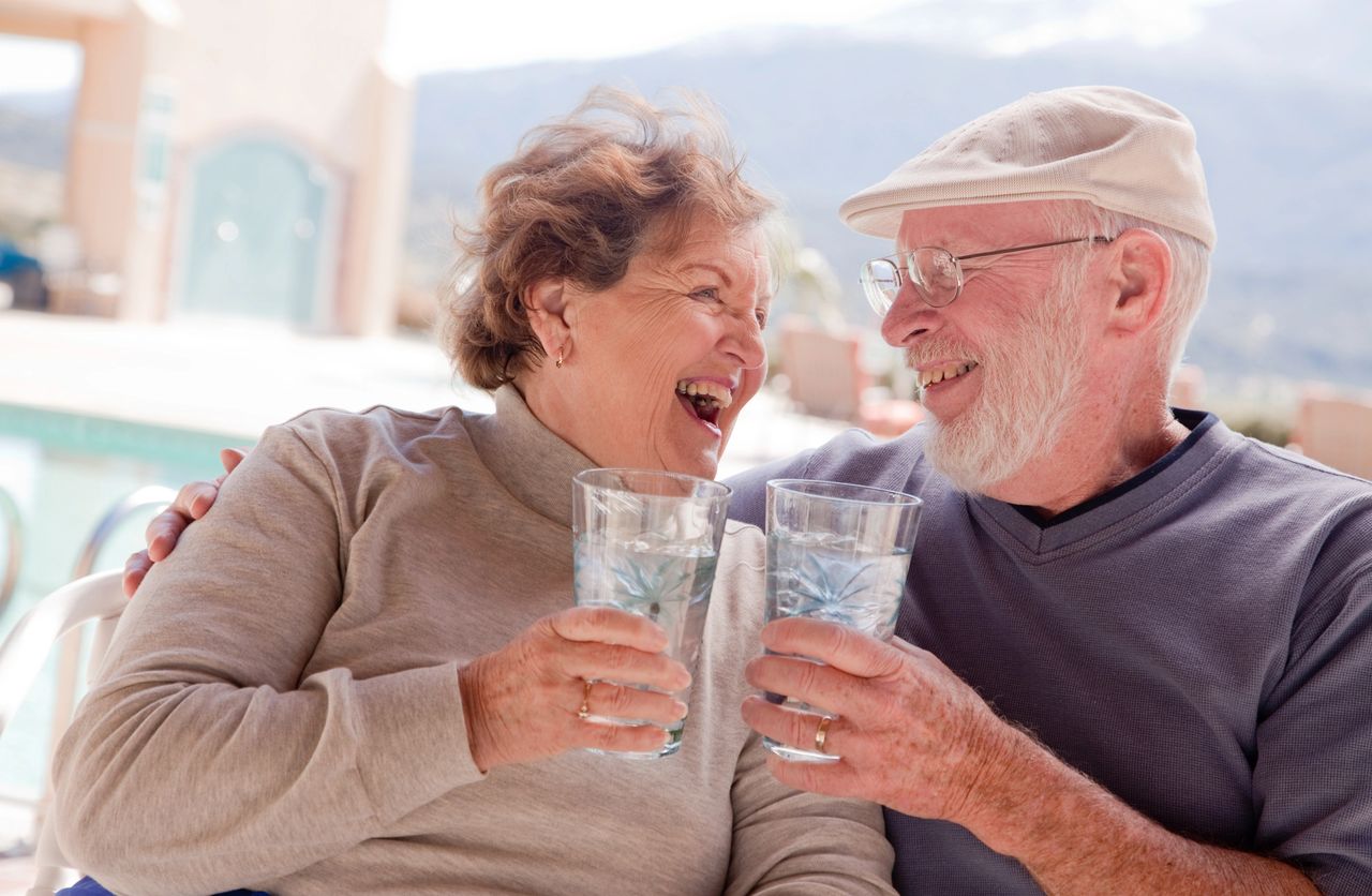 Elderly Couple enjoying a drink a water.
