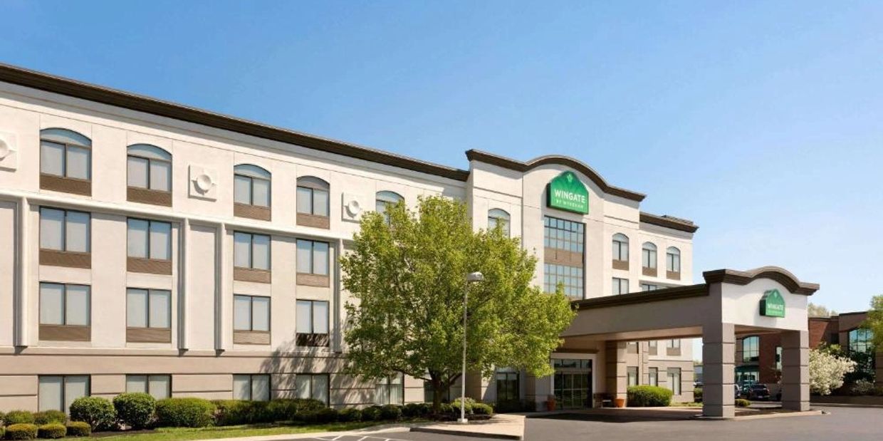 Exterior view of a Wingate by Wyndham hotel under clear blue sky.