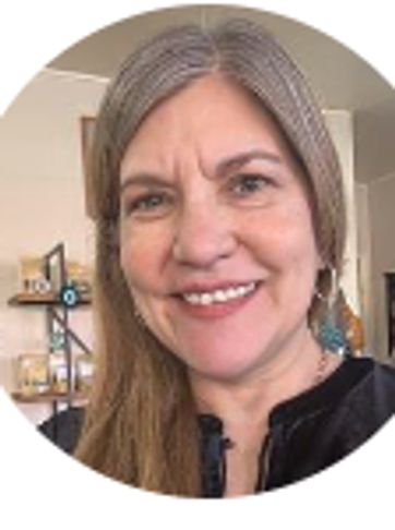 Smiling woman with long hair posing indoors.