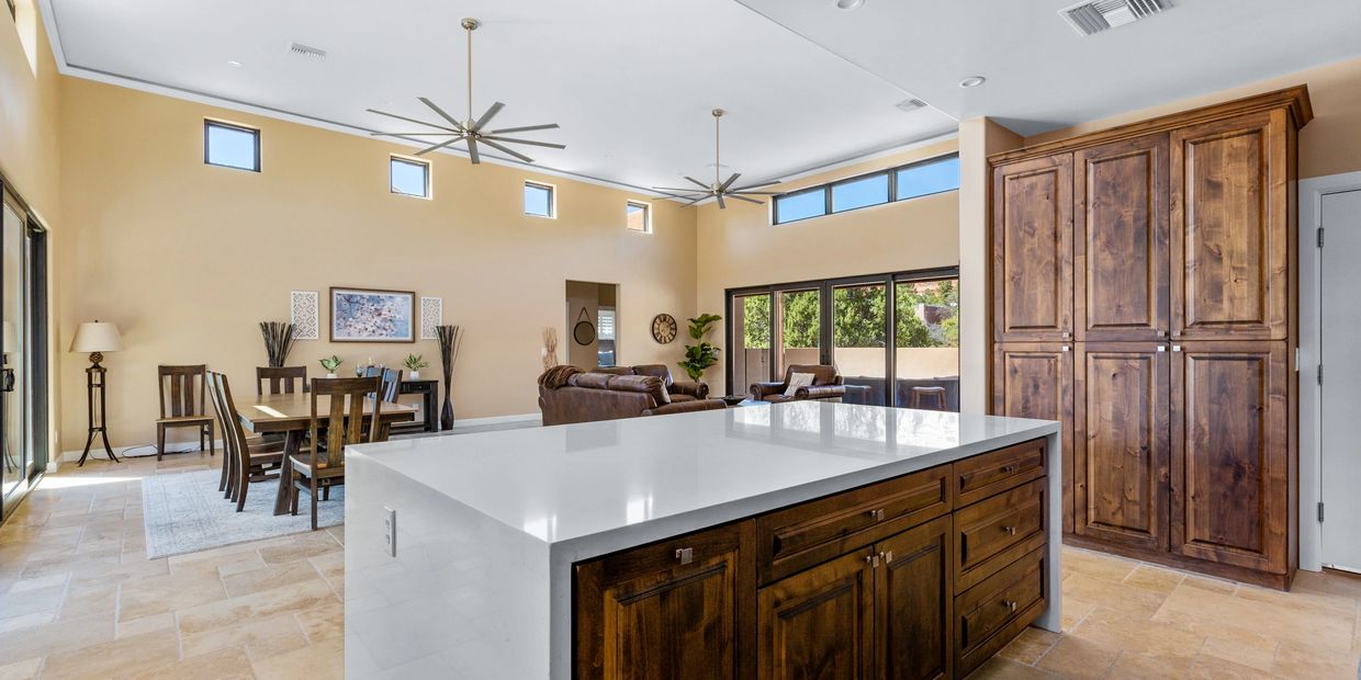 Spacious kitchen and living area with wooden cabinets and large island.
