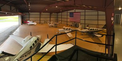 Small planes parked inside a hangar.
