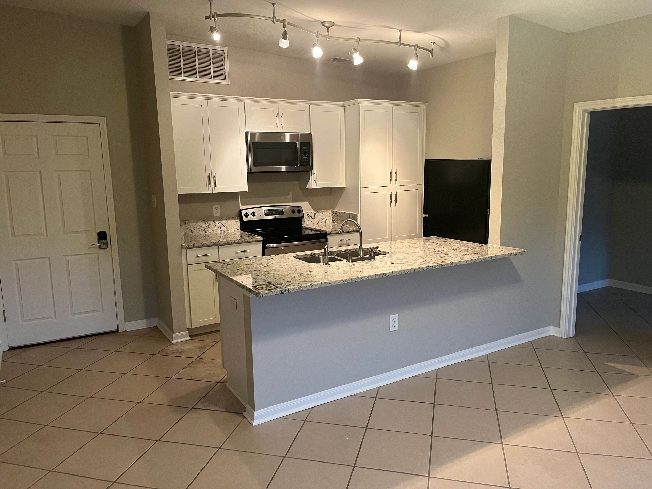 Modern kitchen with granite countertops and stainless steel appliances.