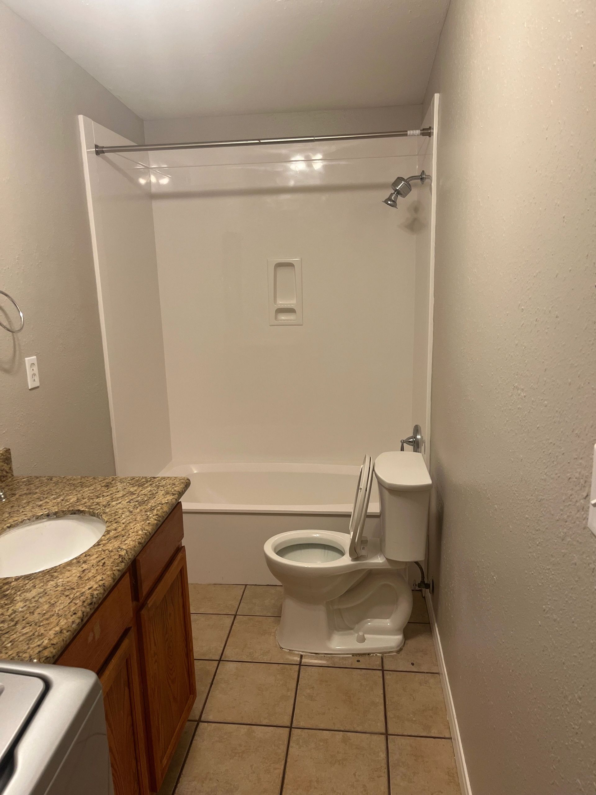 A simple bathroom with a bathtub, toilet, and sink.