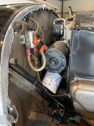 Close-up of a mechanical engine component with wiring and a filter.