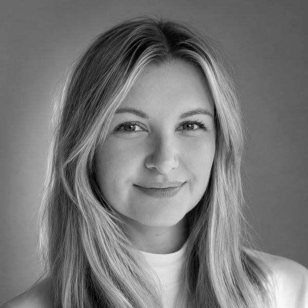 Black and white portrait of a smiling woman with long hair.