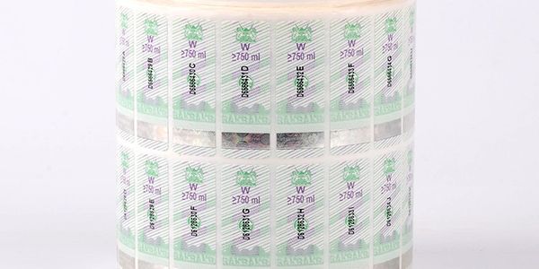 Roll of transparent labels with green and purple markings.