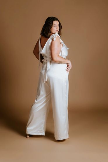 Silk satin jumpsuit with a shoulder tie strap detail and wide leg pant.
Elopement bridal outfit.