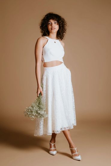 Contemporary bridal outfit for a relaxed wedding. Wedding crop top with a matching floral lace skirt