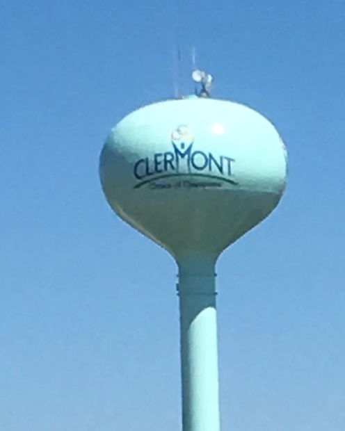 Water tower labeled Clermont against blue sky.