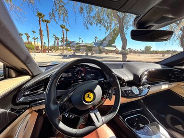 Inside the Ferrari Purosangue cockpit looking at an F-16 gate guardian from the Palm Springs Air Mus