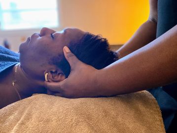 Black woman laying down having a scalp massage