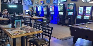 Dart machines and a pool table inside That Place Bar & Grill.