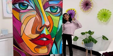 Zoya posing for a picture with her art work