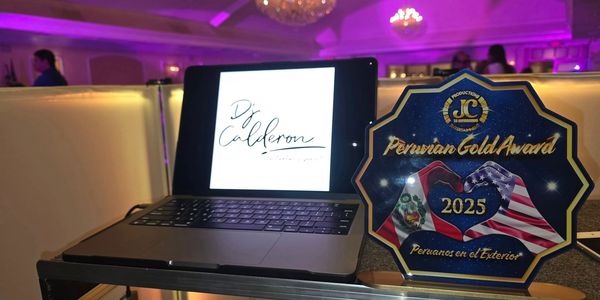 Laptop with DJ Calderon's logo and a Peruvian Gold Award 2025 plaque on a table.