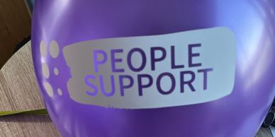 Purple balloon with 'People Support' text printed on it.