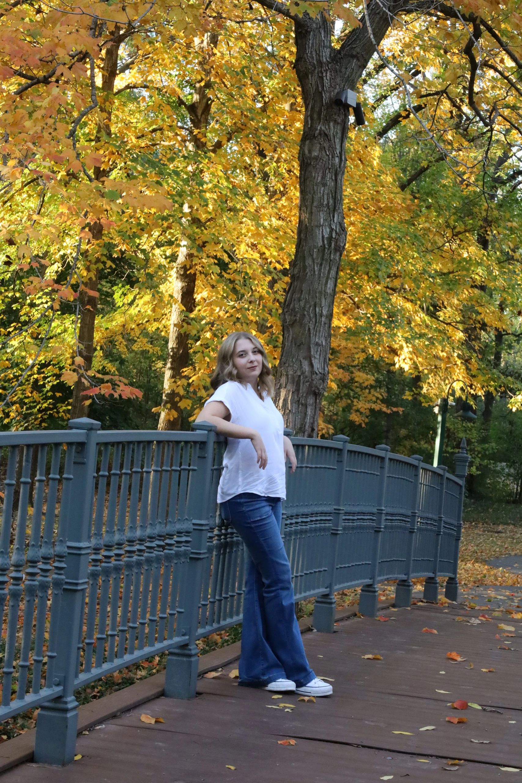 Woman leaning on a fence in autumn.