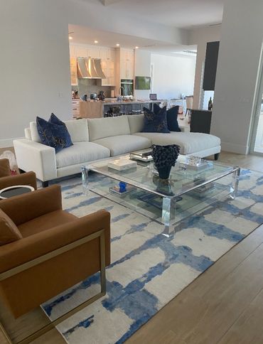 Blue & white rug with white sofa and leather chairs